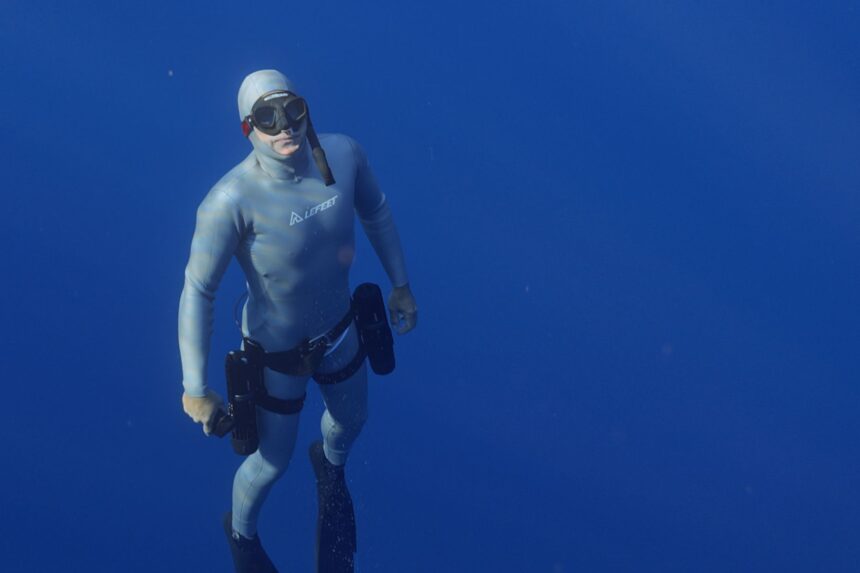 Our tester freediving in open blue water with LEFEET P1 units strapped to both thighs