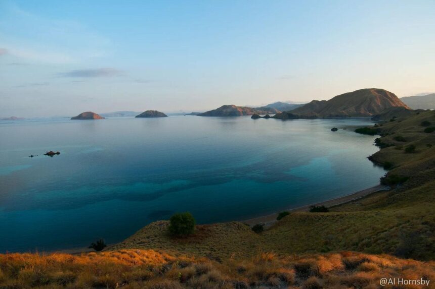 a calm bay in Komodo with hills and small islands at dusk