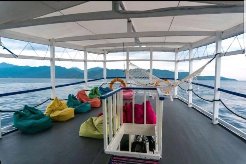 a covered deck with a hammock and colorful beanbags overlooking hills