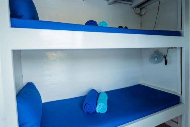Bunk bed cabin aboard the Epica with rolled towels and a small fan