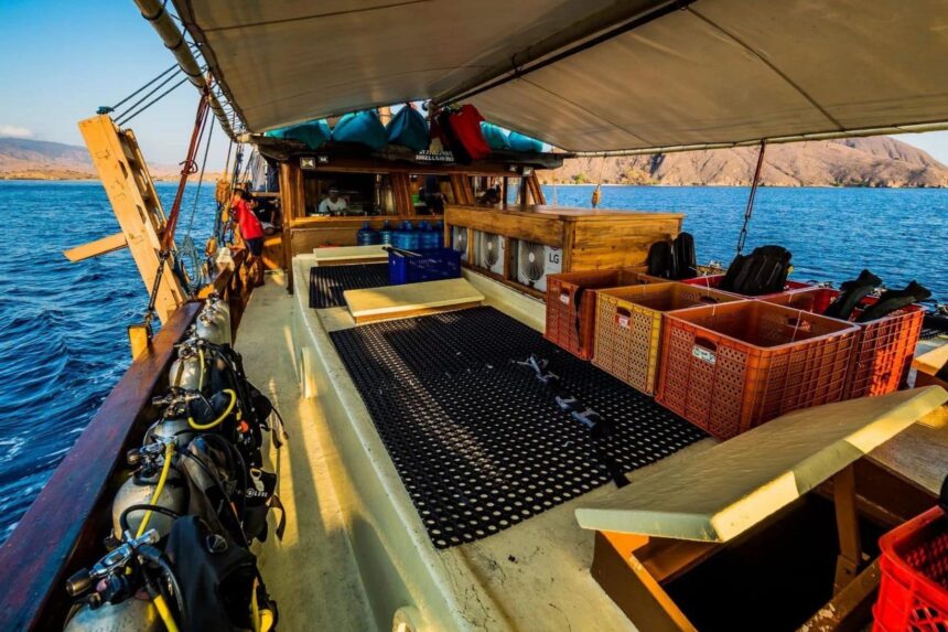 Dive deck of the Jaya liveaboard loaded with tanks, gear crates and equipment
