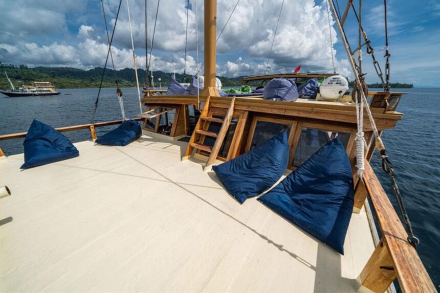 Blue bean bags laid out on the Jaya's bow deck under a sailboat rig