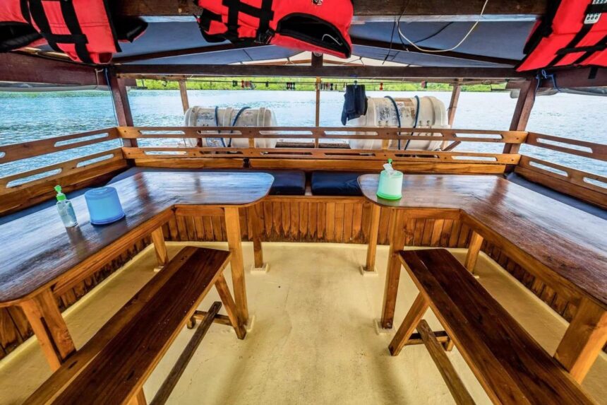 U-shaped wooden bench seating around tables on the Jaya's stern deck