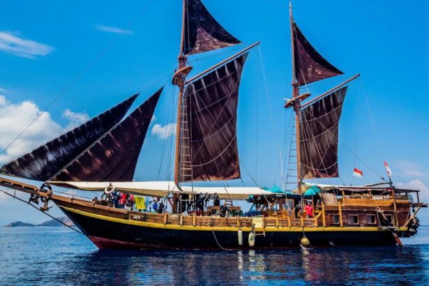 Close view of the Jaya's dark sails and rigging with divers gathered on deck