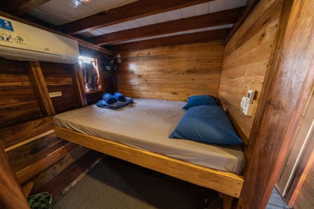 Wooden double cabin aboard the Jaya with a made-up bed and air conditioning unit