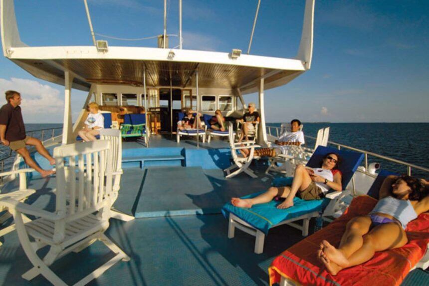Guests relaxing on sun loungers on the Manthiri's upper deck in the late afternoon sun