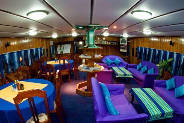 Teak-paneled salon aboard the Manthiri with purple sofas and dining tables