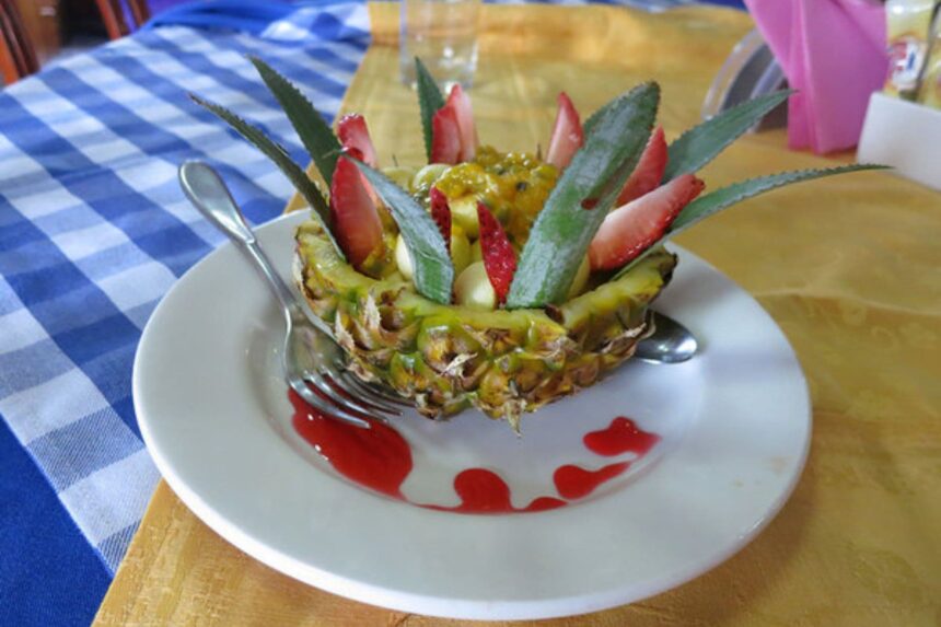 pineapple boat filled with fresh fruit and berry coulis served aboard Manthiri