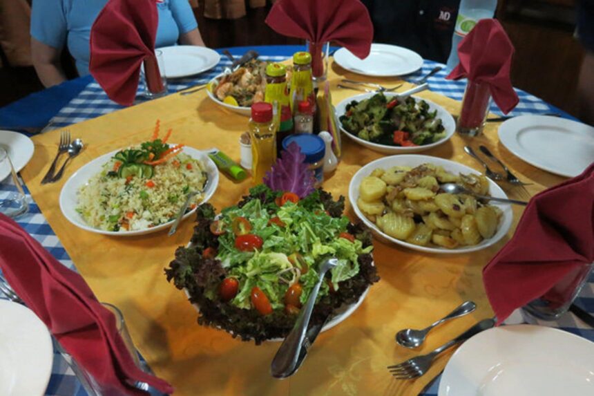 dining table spread with salads, roasted vegetables and fresh fruit aboard Manthiri