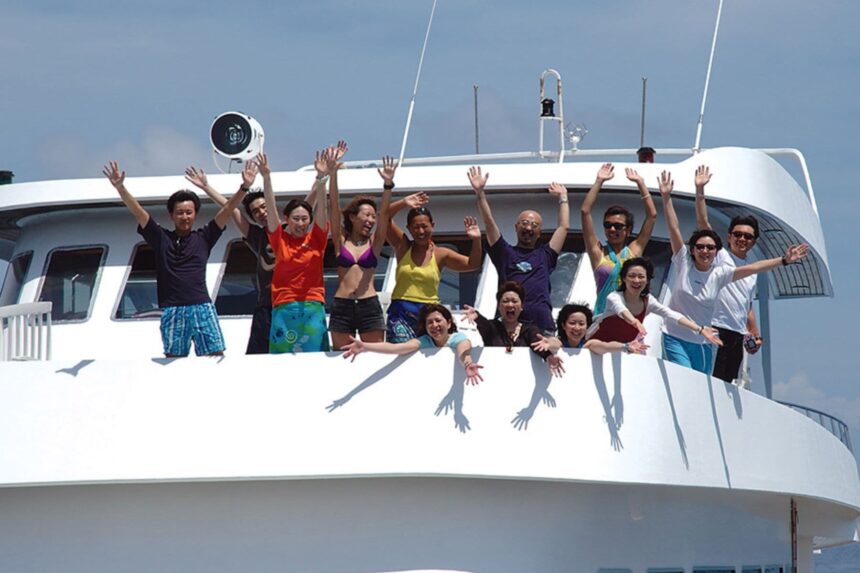 Group of guests waving and cheering from the Manthiri's upper deck railing