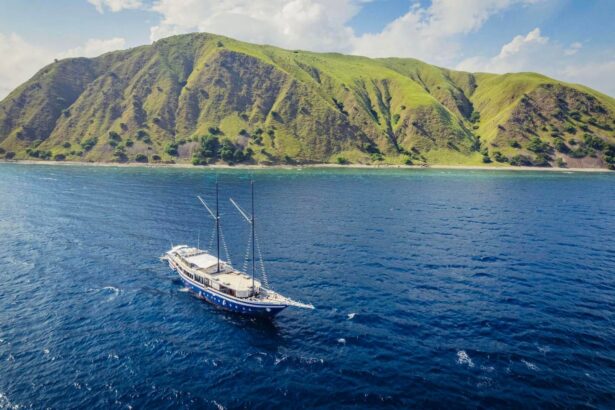 Aerial view of the Scubaspa Zen phinisi sailing past a green coastal hillside