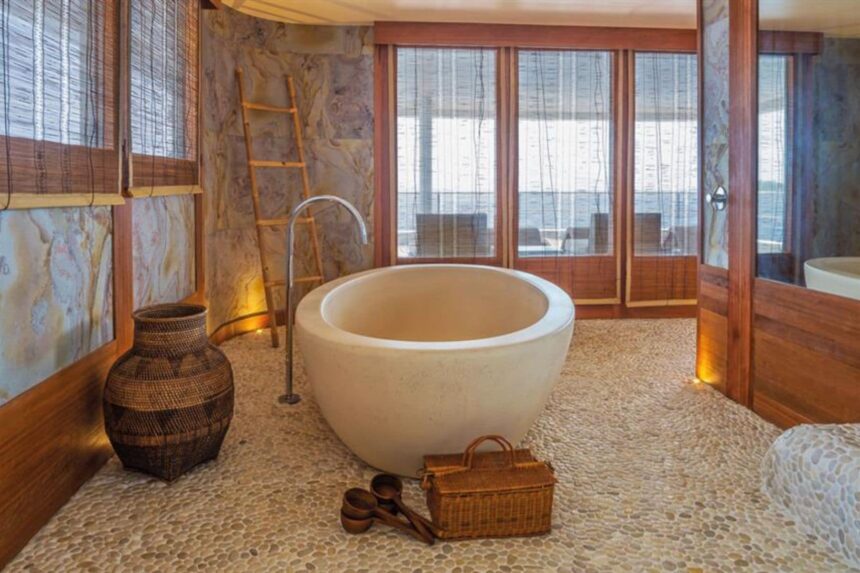 Freestanding stone soaking tub in a spa room aboard Scubaspa Yin