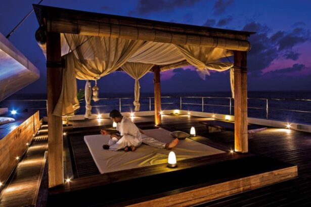 A therapist giving a massage inside an open-air cabana on deck at night