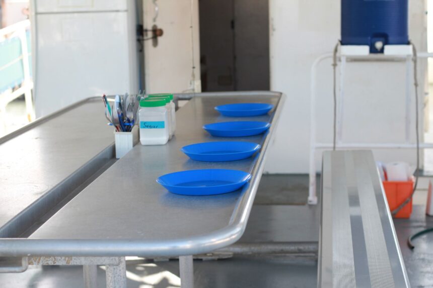 Blue plates set on a communal dining table aboard MV SeaEsta