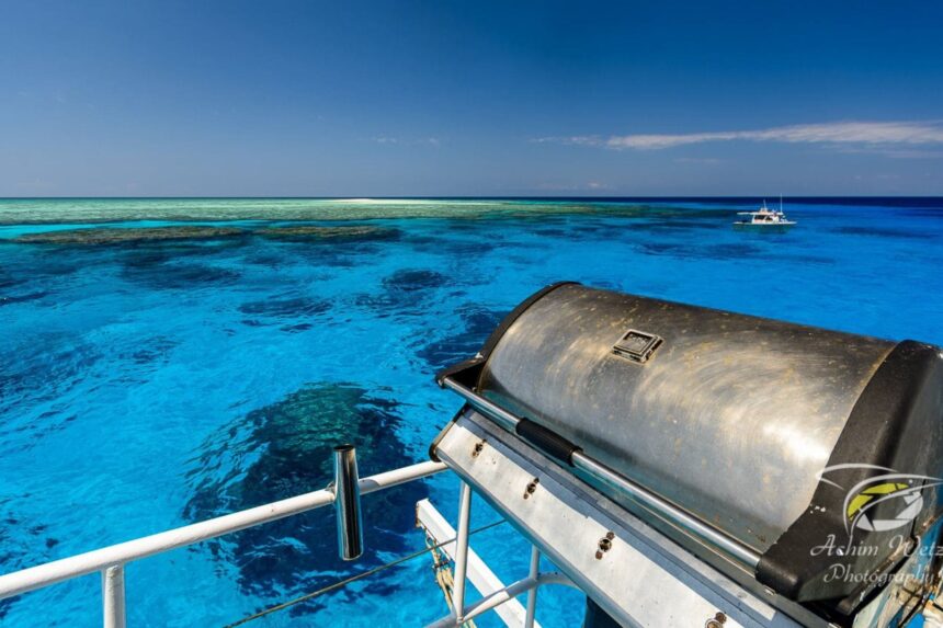 Barbecue grill on deck overlooking turquoise Great Barrier Reef waters