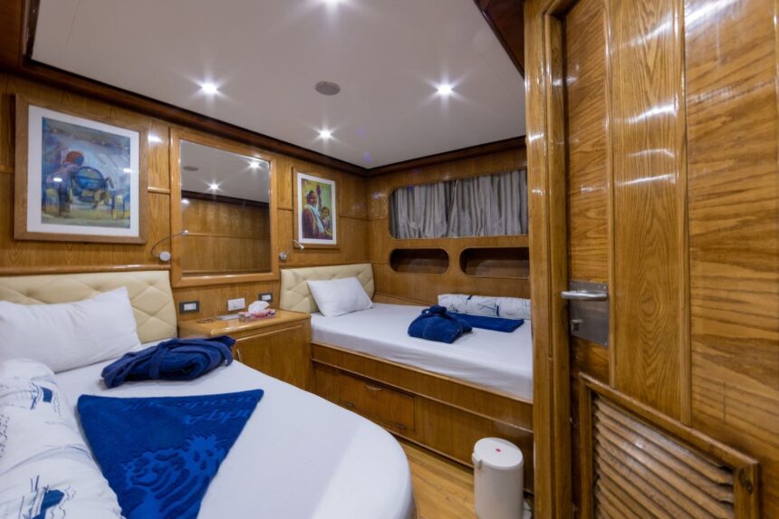 Twin-bed cabin with wood paneling aboard the Aphrodite liveaboard