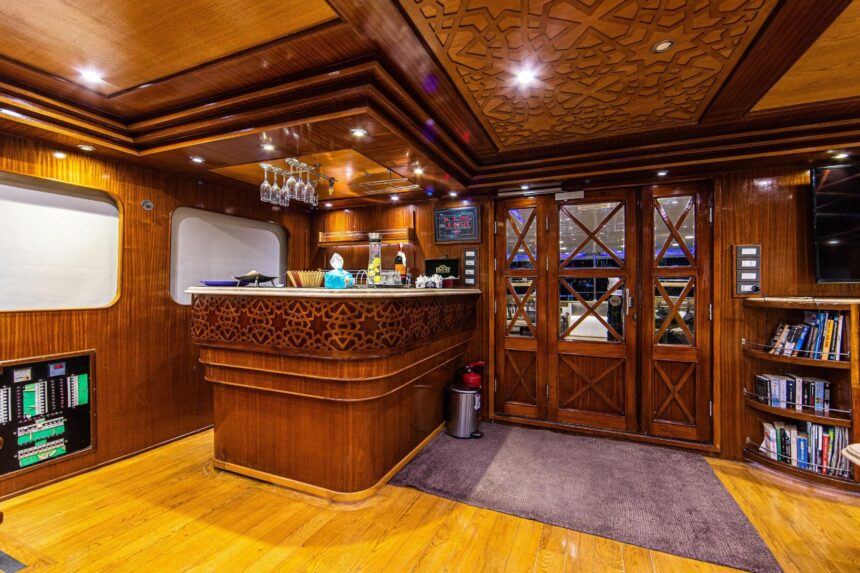 Wood paneled bar and bookshelf lounge area aboard the Aphrodite