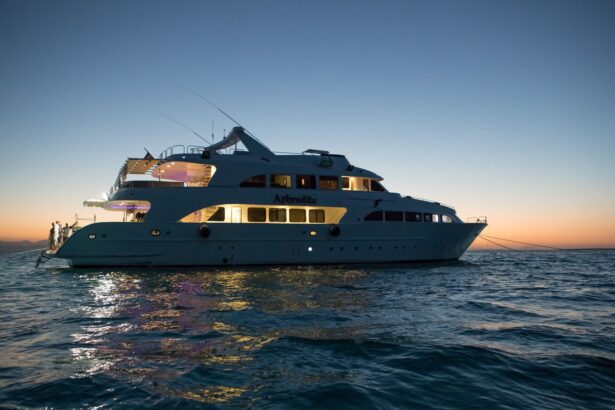 Aphrodite liveaboard anchored at sea at sunset with lights glowing