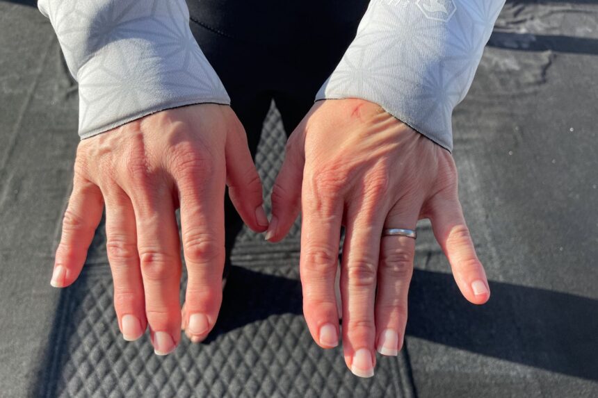 DIVEIN tester showing the snug wrist cuffs of the Aqualung XSCAPE wetsuit on the boat deck