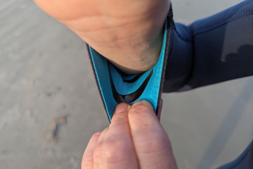 Our tester pulling back the rubber-lined wrist seal on the Fourth Element Surface wetsuit
