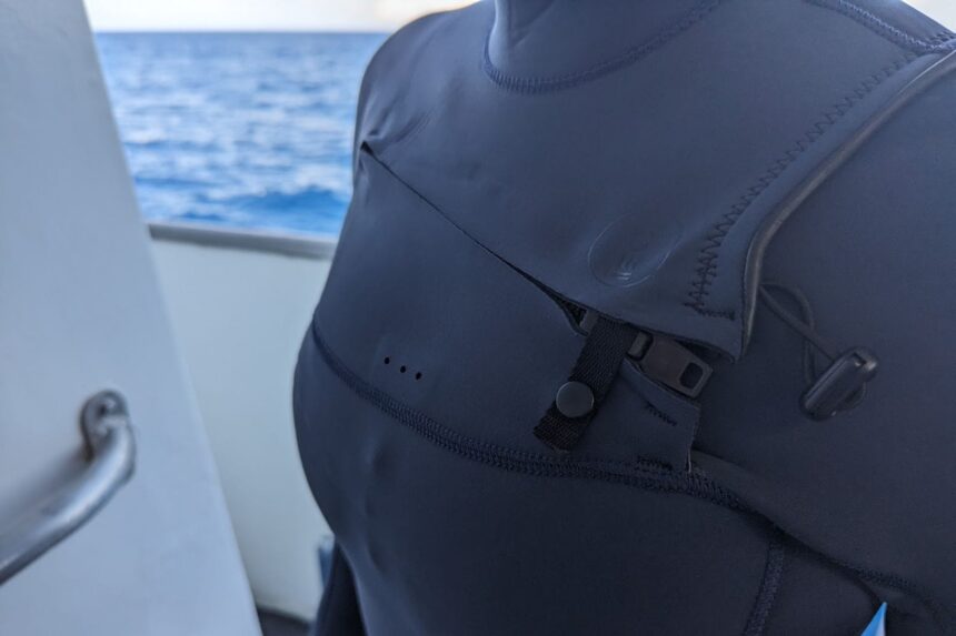 Detail of the mini zip, fastener and toggle on the shoulder of the Fourth Element Surface wetsuit