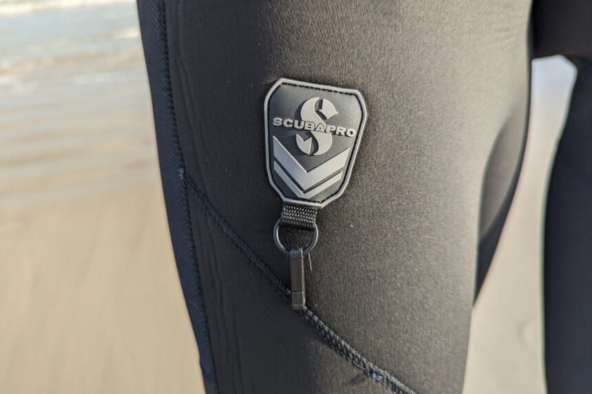 Close-up of the ScubaPro rubber logo badge and accessory D-ring on the Everflex Yulex wetsuit thigh