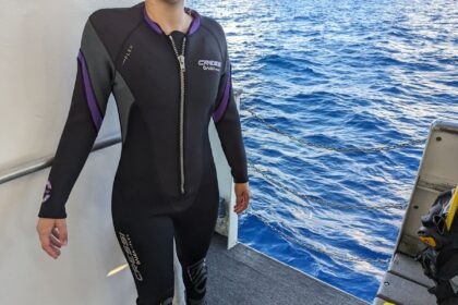 Front zip and purple side panels of the Cressi Bahia Flex wetsuit worn by our tester on a dive boat