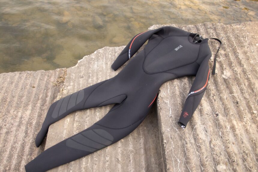 Fourth Element Proteus II wetsuit laid on a concrete slipway showing the full leg and arm panels