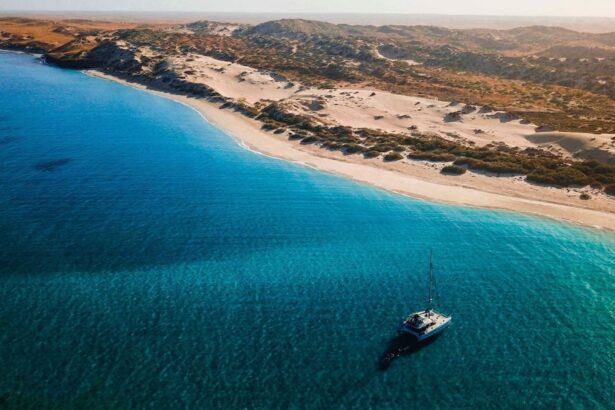 Aerial view of the Shore Thing catamaran anchored off a remote sand dune coastline