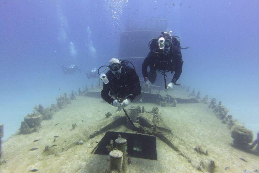 Testing Dive Over A Sunken Wreck Two divers hovering over a sunken wreck deck in clear blue water during DIVEIN testing