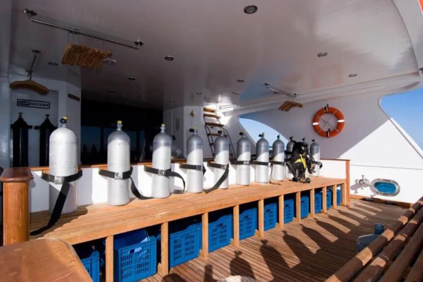 Scuba tanks lined up on the Aldebaran liveaboard's dive deck