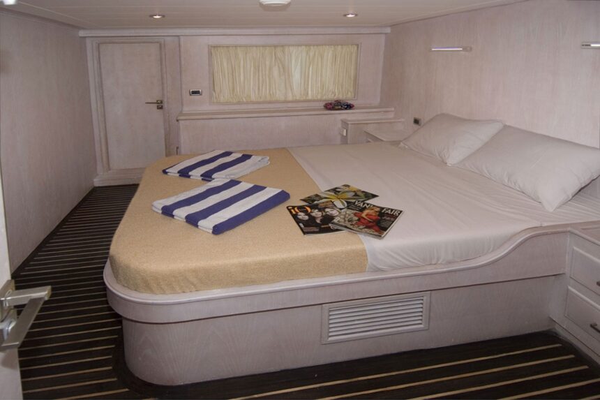Cabin bed on the Aldebaran with folded towels and magazines