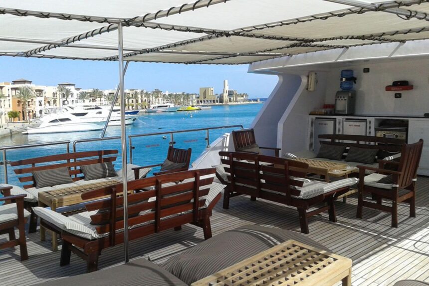 Wooden deck seating overlooking a marina lined with buildings
