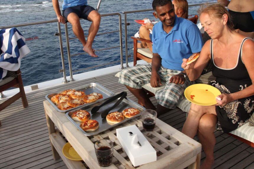 Guests enjoying homemade pizza together on the Aldebaran's deck