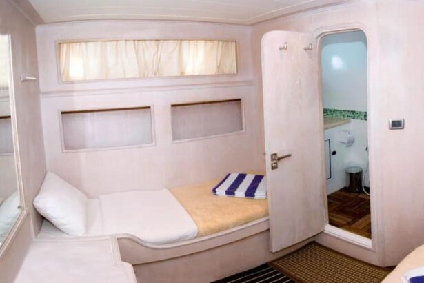 Cabin bed beside an open ensuite bathroom door aboard the Aldebaran