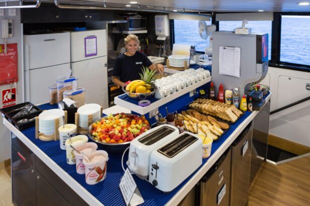 Crew member setting out a fresh fruit and toast breakfast buffet