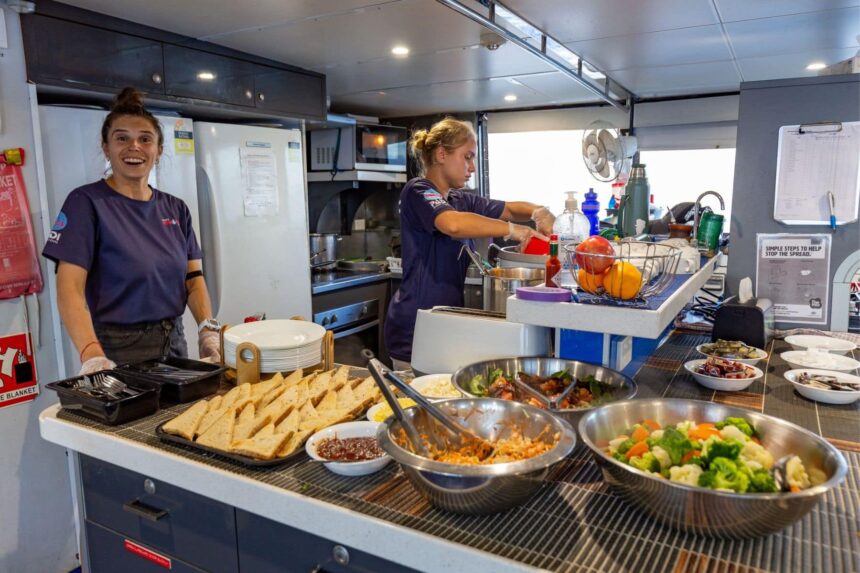 Crew preparing a buffet of sandwiches and salads onboard