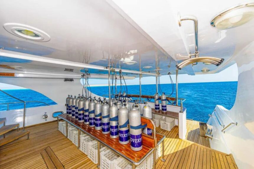 Rows of scuba tanks labeled Discovery lined up on the dive deck