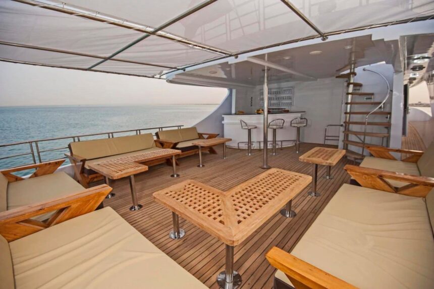 Covered lounge seating on the Discovery II's upper deck with a spiral staircase