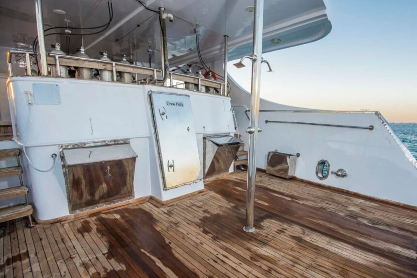 Crew work area on deck with tanks, storage lockers, and a wooden crew-only door