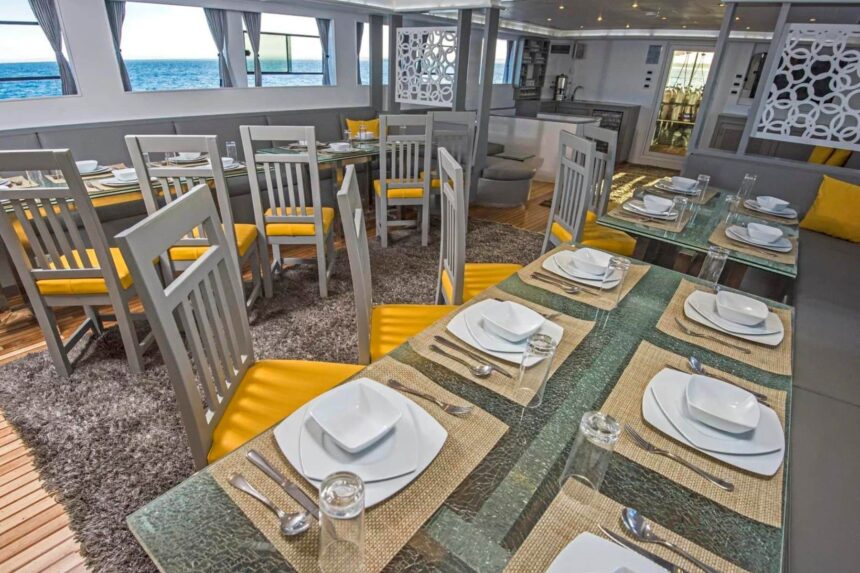 Dining tables set with plates and glasses in the Discovery II's dining room