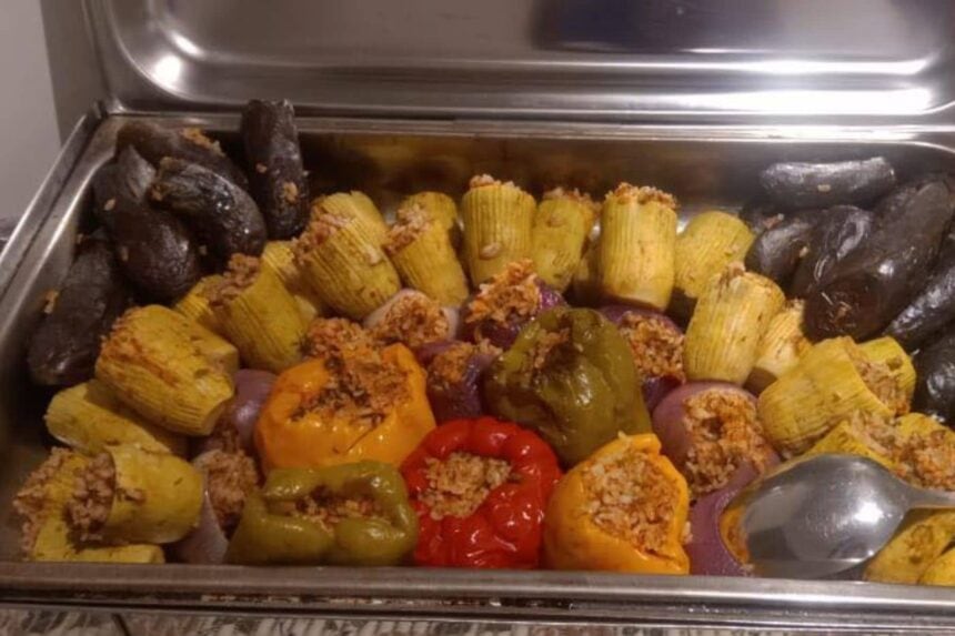 Stuffed peppers, onions, and vine leaves arranged in a serving tray