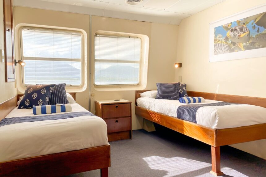 Twin bunk cabin with blue striped bedding aboard OceanQuest