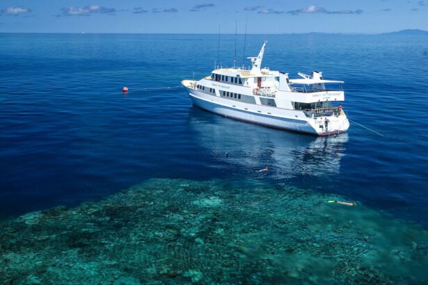 Spirit of Freedom liveaboard anchored over a reef with snorkelers in the clear water below