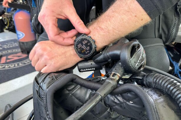 Our tester adjusting the Garmin Descent Mk3i on his wrist over wet dive gear right after a dive
