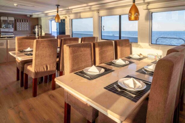 Dining tables under woven pendant lamps beside windows facing the sea