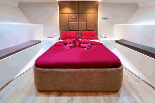 Cabin with a red-linened double bed and towel decorations