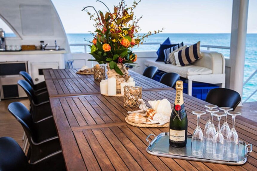 Champagne and glasses set on the outdoor dining table aboard MV Great Escape
