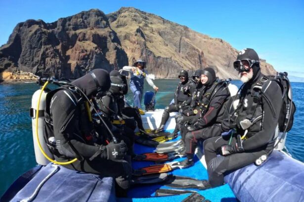 Divers seated on the tender preparing to enter the water near volcanic cliffs