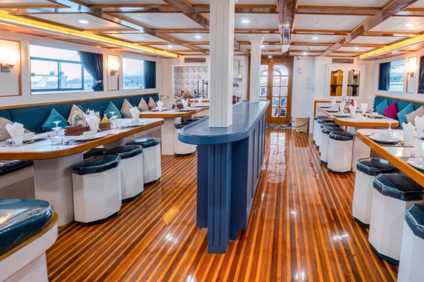 Wood paneled dining salon with a blue bar aboard Titan